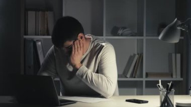 Geç saate kadar çalışmak yorgunluk uykucu adam dizüstü bilgisayarı kapatıyor