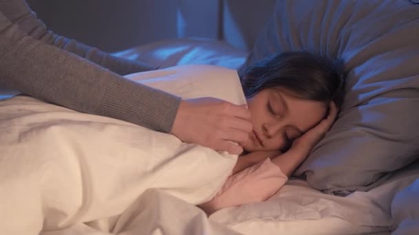 God natt mor vård liten flicka sover i sängen — Stockvideo