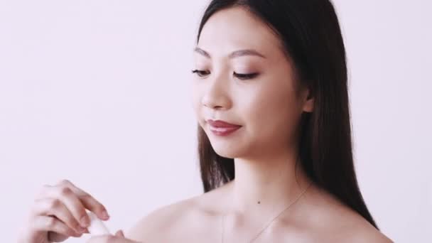 Asiatico cosmetici cura della pelle donna applicando crema — Video Stock