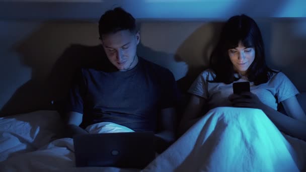 Gadget noche digital pareja usando teléfono portátil cama — Vídeos de Stock