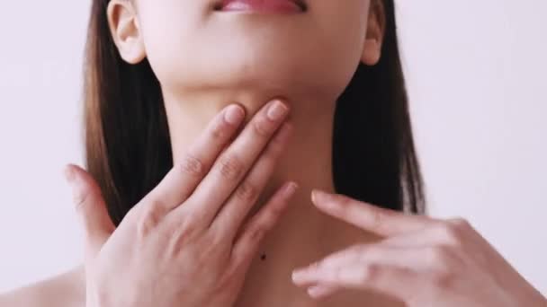 Увлажняющая кожу женщина трогает шею — стоковое видео