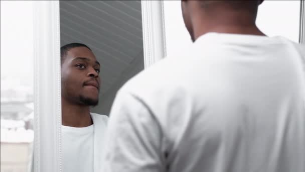 Cuidado de la piel masculino hombre africano feliz mirando en el espejo — Vídeo de stock