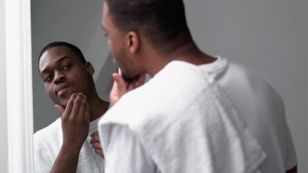 Mężczyzna pielęgnacja skóry trądzik leczenie afrykański dotykanie twarzy — Wideo stockowe