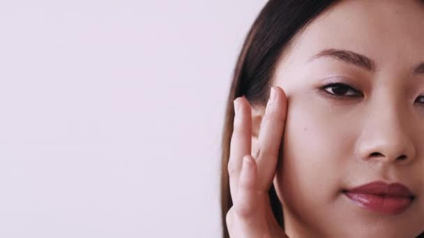Обличчя скінаре розслаблена азіатська жінка торкається обличчя — стокове відео
