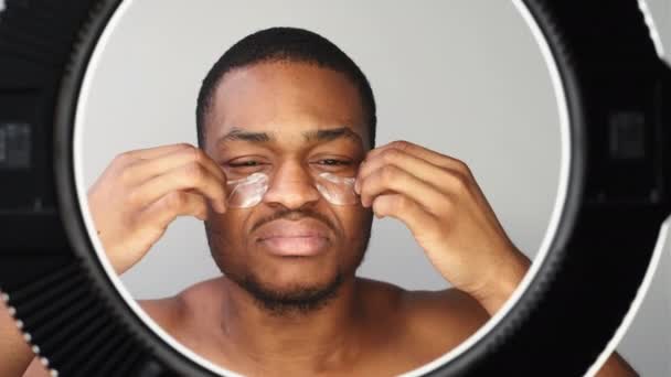 Homem skincare confuso Africano removendo manchas oculares — Vídeo de Stock
