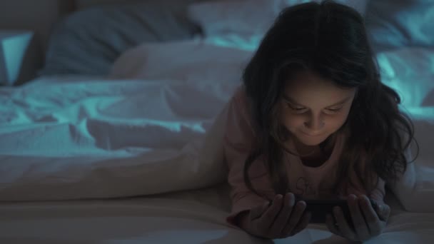 Bedtime film per bambini notte ragazza guardando il telefono a letto — Video Stock