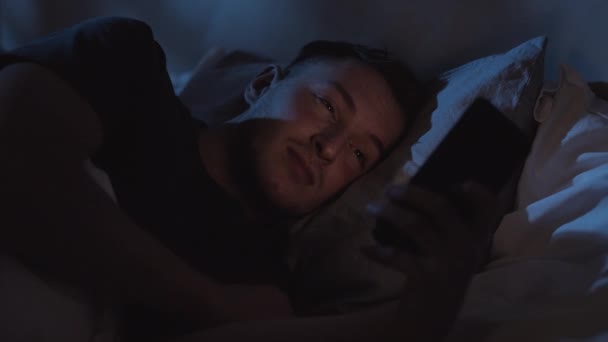 Noc online noční zvyk uvolněný muž pomocí telefonu — Stock video