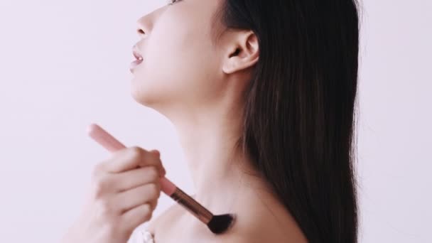 Asian makeup skin whitening woman using face brush — Stock Video