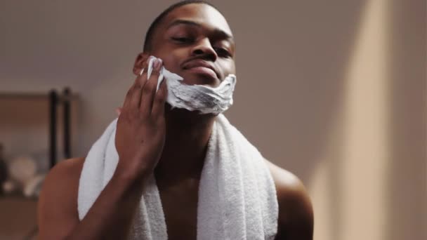 Homme homme africain soins de la peau appliquant mousse à raser — Video