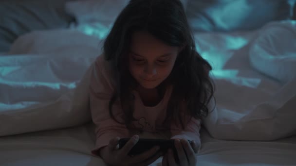 Nuit film enfant lit loisirs fille regarder téléphone — Video