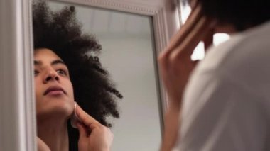 Erkek yüz bakımı pamuk pedi kullanarak temizliyor