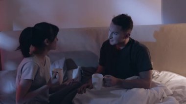 Gece haberleşmesi mutlu çift yatakta gülüyor