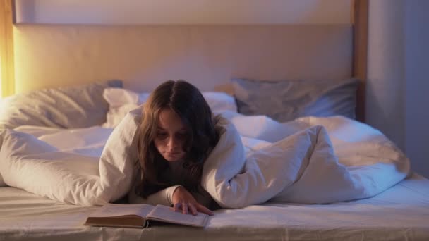 Criança hobby noite lazer menina leitura livro na cama — Vídeo de Stock