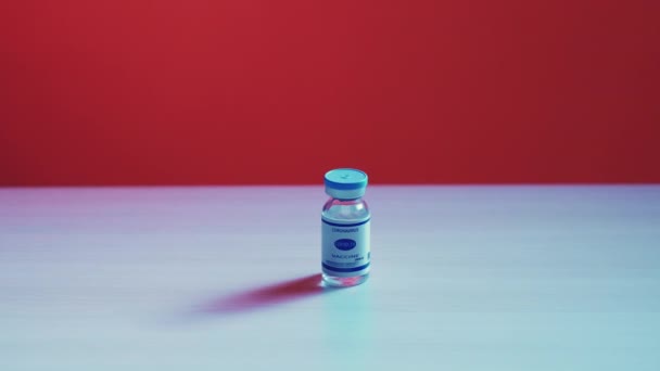 Fiolka ze szkła zawierająca szczepionkę covid-19 z etykietą na czerwono — Wideo stockowe