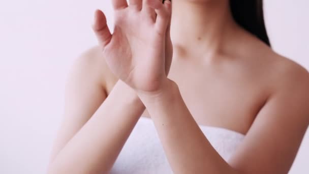 Aziatische huidverzorging vrouw in handdoek het aanbrengen van handcrème — Stockvideo