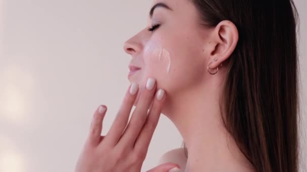 Cura del viso idratante della pelle della donna applicando crema — Video Stock