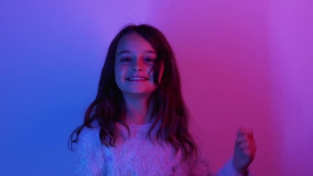 Bambino felice eccitato ragazza carina saltando nella luce al neon — Video Stock