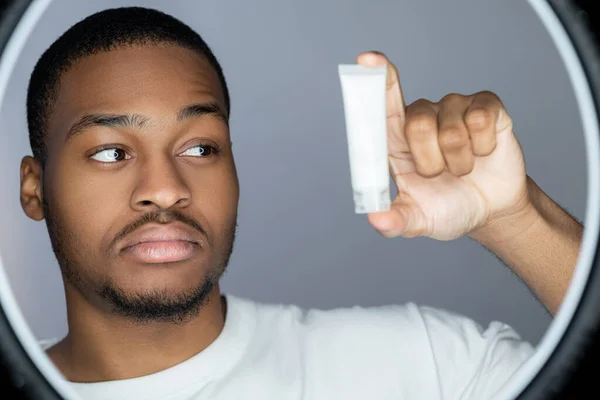 Man huidverzorging gezichtsbehandeling Afrikaanse lotion buis — Stockfoto