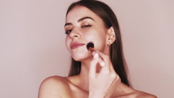 Naakt make-up vrouw aanbrengen gezicht poeder met borstel — Stockvideo