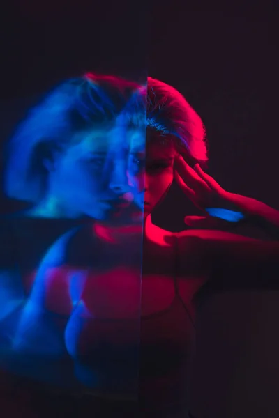 Psykisk störning störd kvinna i rosa blått ljus — Stockfoto