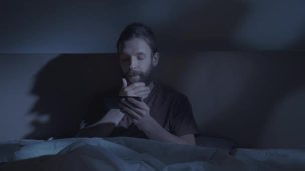 Cama hábito noche película somnoliento hombre viendo teléfono — Vídeos de Stock