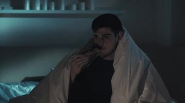 Korku filmi gecesi boş zamanlarında televizyon izleyen korkak bir adam.