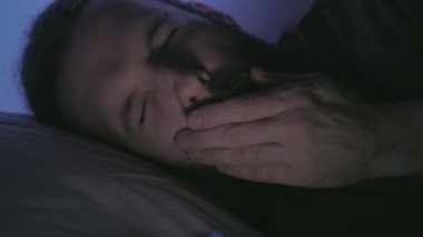 Mobil yorgunluk gece alışkanlığı. Yatakta yorgun adam telefonu.