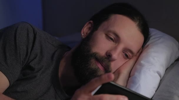 Mobiele nacht bed gewoonte guy kijken film op telefoon — Stockvideo