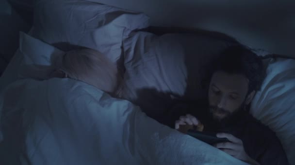 Internet traição noite marido escondendo telefone cama — Vídeo de Stock