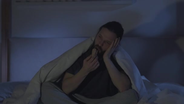 Постільний фільм нічна безсоння нудьгує чоловік дивиться телевізор — стокове відео