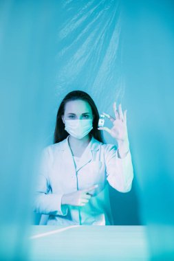 Grip aşısı Coronavirus aşısı. Doktor şişesi mavi üzerine.