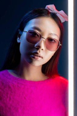 Neon ışıklı gözlüklü çekici kız güneş gözlüklü.