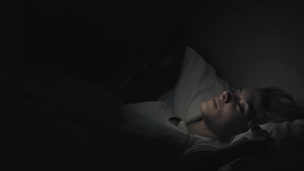 Пізно онлайн жінка засинає, кидаючи телефон — стокове відео