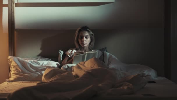 Pozdě čtení noc nespavost žena v posteli s knihou — Stock video