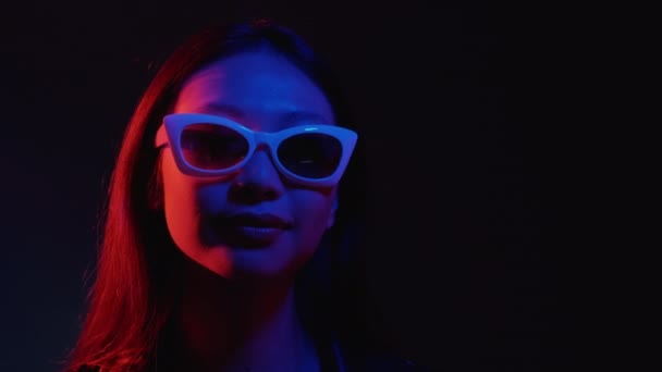 Неонове світло обличчя клубний спосіб життя дівчина в окулярах — стокове відео