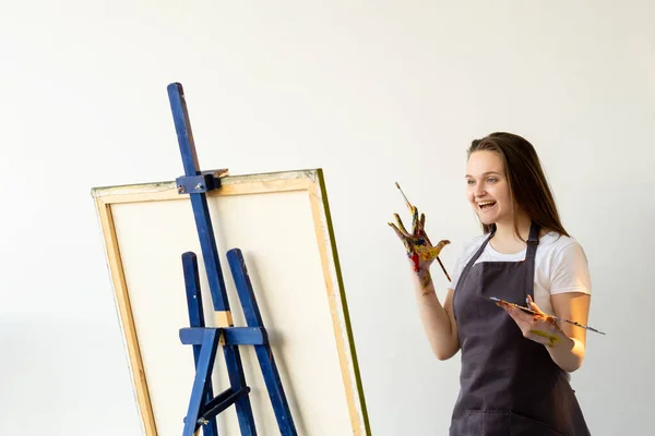 Inspirado artista feminino pintura escola surpreendido — Fotografia de Stock