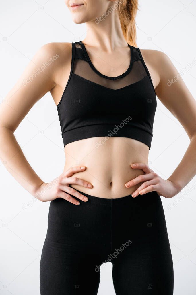 Woman activewear. Clothing template. Sports apparel fashion. Fitness outfit. Front view of female athlete model with slim body in logo mockup black crop top leggings isolated on light.
