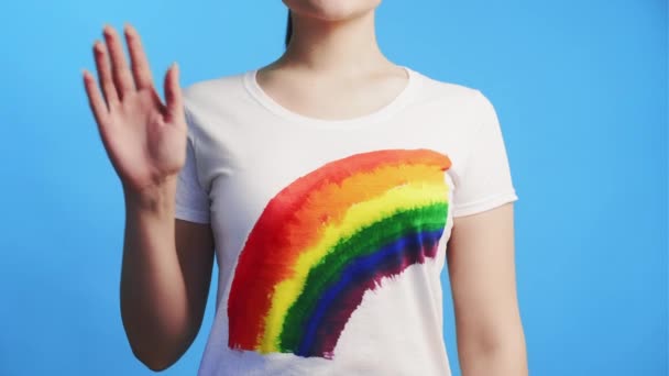 Lgbt Solidaritätsfrau im Regenbogen-T-Shirt winkt hallo — Stockvideo