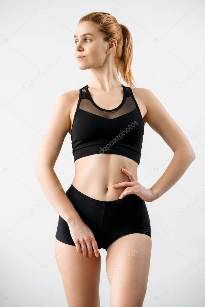 Woman sportswear. Outfit showcase. Workout clothing. Training apparel. Front view of female athlete with slim body in blank label black mesh crop top shorts isolated on light.