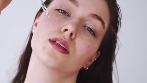 Tvář sérum péče o pleť žena nanášení oleje na kůži — Stock video