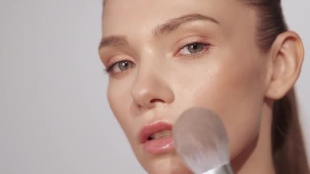 Nude makeup woman applying blush on face skin — Vídeos de Stock