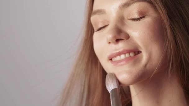 自然妆容的女人用柔软的刷子触摸脸 — 图库视频影像