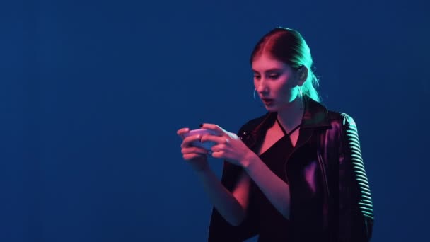 Mobil spel färg ljus flicka spelar på telefon — Stockvideo