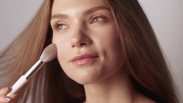 Beauté maquillage femme toucher la peau du visage avec brosse — Video