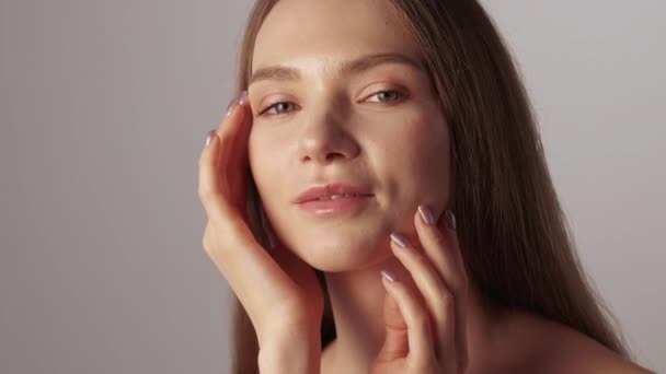 Увлажняющая кожу лица женщина трогает лицо — стоковое видео