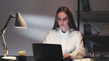 Laptop kullanan uzaktan kumandalı bir kadın.
