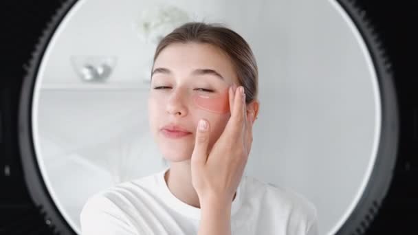 Sous les yeux femme soin de la peau appliquant des patchs hydrogel — Video