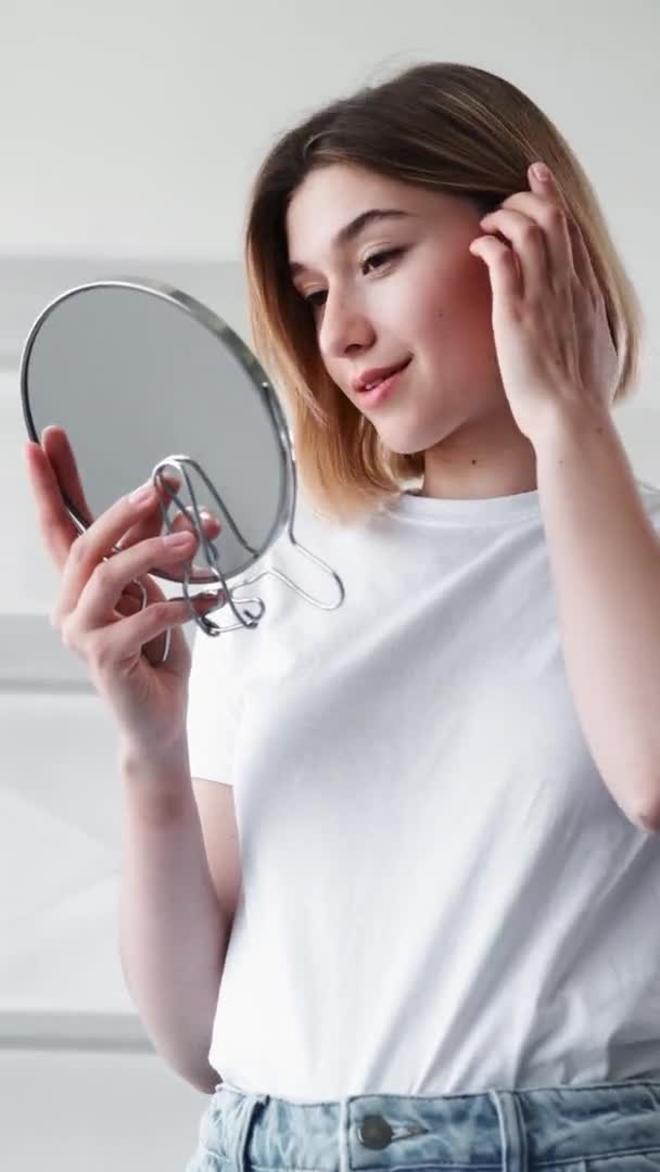 Догляд за шкірою вранці рутинна жінка дивиться у дзеркало — стокове відео