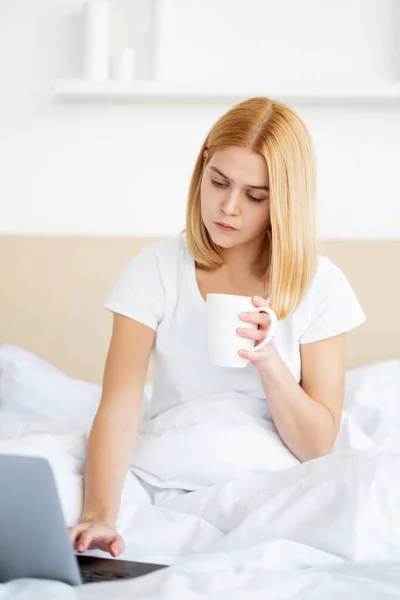 Werk van thuis afgelegen baan vrouw laptop bed koffie — Stockfoto