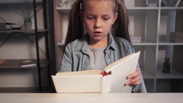 Читання хобі дитяча література здивована дівчина книга — стокове відео